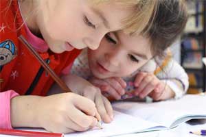 Kids Coloring and Doing Homework in the Kitchen